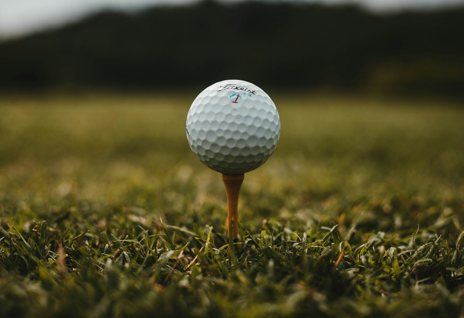 Bola de golf Titleist colocada sobre un tee en la hierba